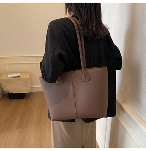 Brown leather tote bag featuring lychee texture and stitching details shown on model