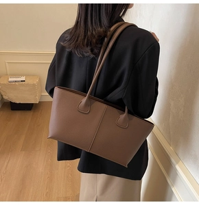 Detailed view of coffee brown litchi leather tote bag with vertical decorative stitching