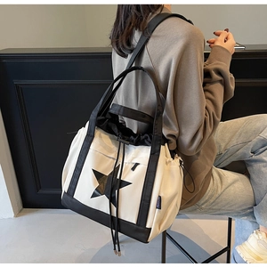 Dettaglio della borsa tote in tela con grande motivo a stella nera e coulisse