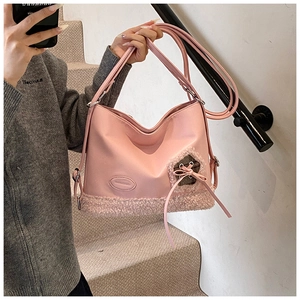 Bolso rosa de cuero PU con ribete de piel sintética y lazo mostrado por una modelo