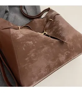 Close-up of brown tote bag showing mixed textures with matte fabric and smooth leather trim