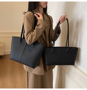 Size comparison of large and small black pebbled leather tote bags with shoulder straps
