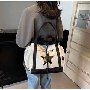 Dettaglio di una borsa shopper bianca e nera con stampa a stella e coulisse
