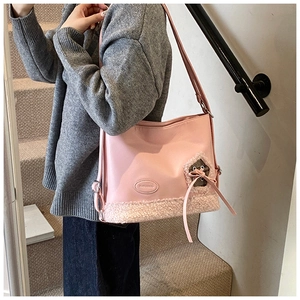 Detalle del bolso tote rosa claro con textura de cuero y ribete de piel en una escalera