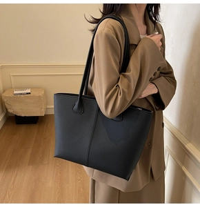 Detail of a black textured leather tote bag showing the matte finish and sleek design