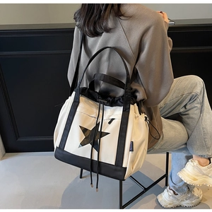 Dettaglio borsa shopper bianca con stella, coulisse nera e tracolla a contrasto