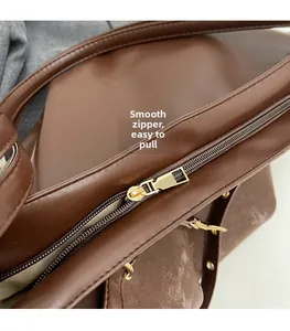 Detail of a smooth golden metal zipper on a dark brown vintage style faux leather tote bag