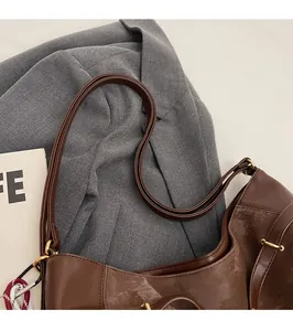 Detail of durable brown PU leather strap and gold hardware on retro tote bag