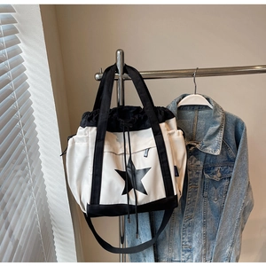 Dettaglio della grande borsa tote in bianco e nero con stella e chiusura a coulisse