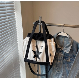 Dettaglio della borsa tote bianca in nylon con stella, chiusura a coulisse e manici