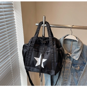 Dettaglio della borsa tote in nylon nero con motivo a stella bianca e tracolla regolabile