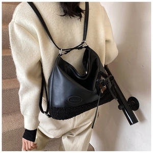 Detalle del bolso tote de cuero PU negro con ribete de pelo sintético y adorno de lazo