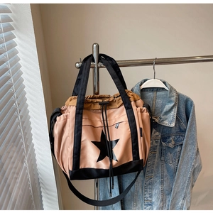 Dettaglio della borsa tote in nylon rosa e nero con motivo a stella e chiusura a laccio