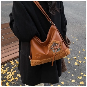Bolso hobo de cuero sintético marrón con ribete de borreguito y detalle de lazo