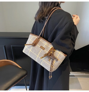 Detail der Vintage-Karotasche mit Fransequaste und Lederbesatz am Modell getragen