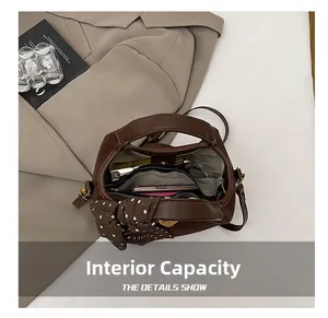 Détails du sac seau en cuir marron foncé montrant le rangement interne pour portable