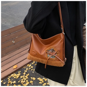Detalle del bolso tote de invierno marrón con retazos de felpa y diseño de cuadros