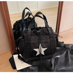 Dettaglio della borsa tote in nylon nero con stella bianca e chiusura a coulisse