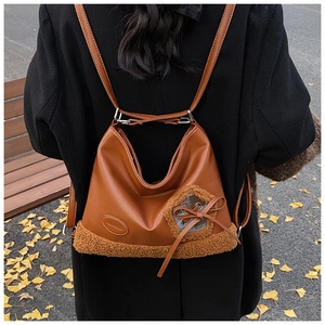 Detalle de mochila vintage de cuero PU marrón y felpa con un lazo a cuadros