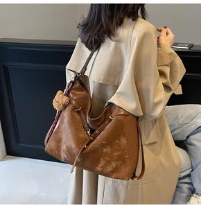 Brown suede tote bag with bear charm and silk scarf shown from a back view