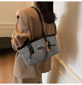 Detailansicht der Hahnentritt-Schultertasche mit Lederriemen und Schlüsselanhänger