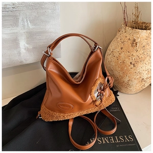 Primer plano del bolso tote marrón en piel PU con ribete de pelo sintético y lazo