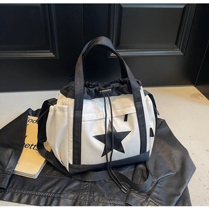 Dettaglio della borsa tote in nylon con coulisse, stella nera e tracolla regolabile