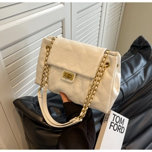 Close-up of white quilted leather bag with golden chain strap and metallic swivel lock
