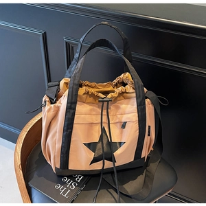 Dettaglio della grande borsa tote con stella nera, coulisse e tessuto in nylon rosa