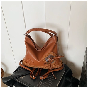 Detalle del bolso tote de cuero marrón con fondo de borreguito y lazo de cuadros