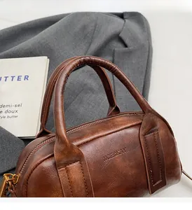 Macro shot of brown leather vintage Boston bag with fine texture and branded logo