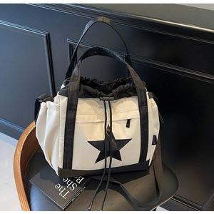 Dettaglio della borsa tote in tela con stella nera e chiusura a coulisse sulla sedia
