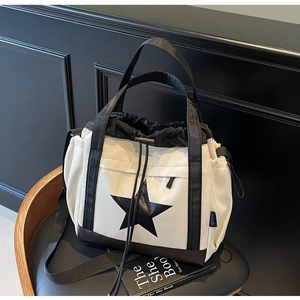 Dettaglio della borsa tote in nylon crema con chiusura a coulisse e grande stella nera