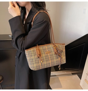 Detailansicht der Retro-Handtasche mit Hahnentrittmuster und braunem Lederriemen an der Schulter