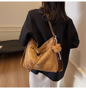 Close-up of brown vintage large-capacity tote bag with cute plush bear keychain
