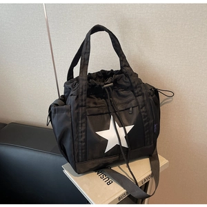 Dettaglio borsa tote in nylon nero con stella bianca e tracolla regolabile rimovibile