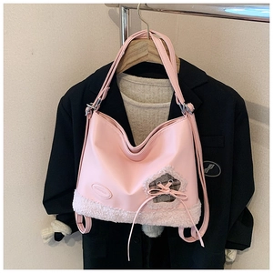 Detalle del bolso tote rosa en ecocuero con fondo de forro polar y adorno de lazo