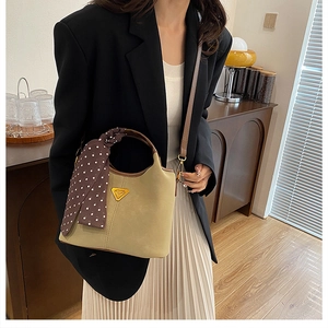 Sac seau vert olive avec foulard en soie et bandoulière porté par un mannequin