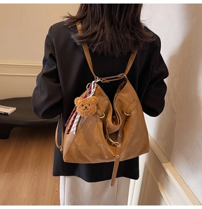 Brown leather large tote bag featuring bear pendant and striped ribbon detail for casual style