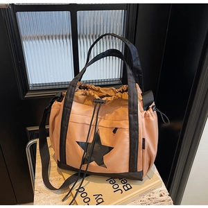Dettaglio borsa tote in nylon kaki con stampa a stella nera su sfondo minimale