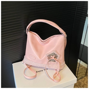Detalle de bolso rosa con borde de pelo sintético, recorte de corazón y lazo de cuadros