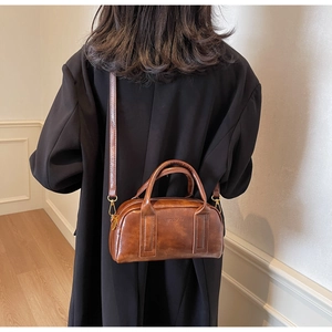Brown vintage leather crossbody bag shown on model for realistic size perspective
