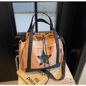 Dettaglio della grande borsa tote in nylon con design a stella e tracolla regolabile