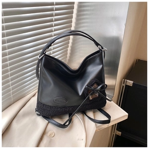 Detalle de bolso hobo negro con borde de lana de oveja y parche de corazón en gabardina