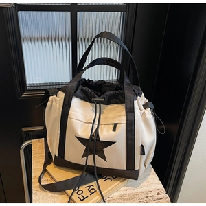 Dettaglio della borsa tote in nylon con chiusura a coulisse e stampa a stella nera