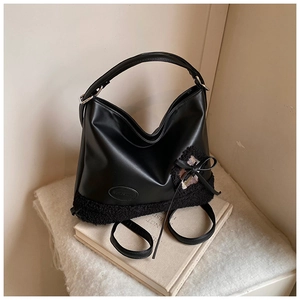 Detalle del bolso tote negro con textura de cuero mate y retales de forro polar suave