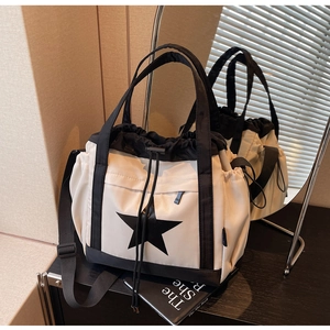 Dettaglio borsa tote in nylon beige con stampa a stella nera e tracolla regolabile