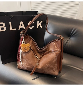 Detail of dark brown vintage faux leather tote with adjustable strap and bear charm