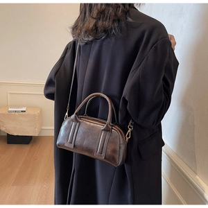 Detailed shot of brown vintage Boston bag featuring retro leather texture and brand embossing