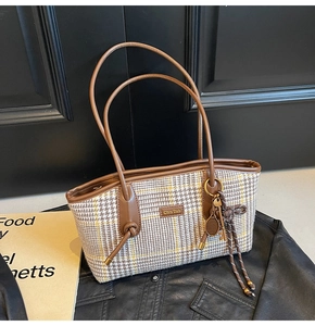 Details der Vintage Handtasche mit Hahnentrittmuster und Tennis-Anhänger